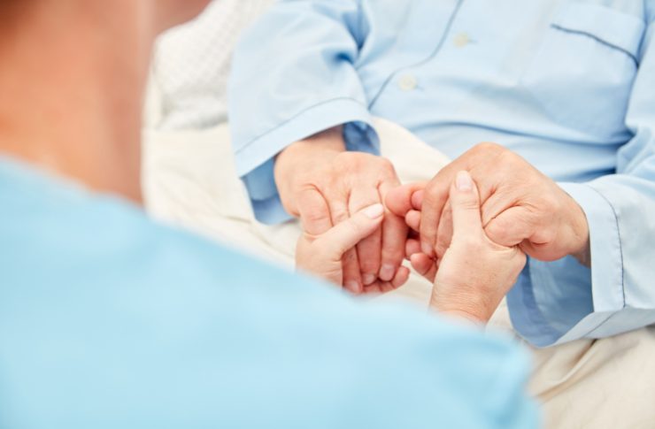 高齢者の手を握る男性