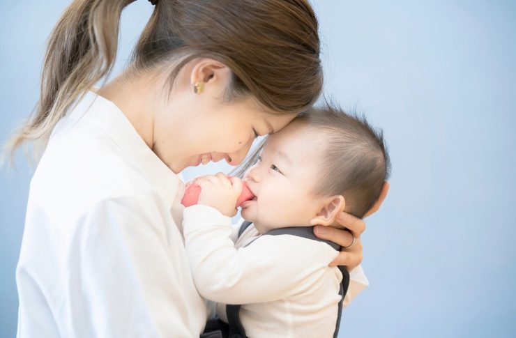 赤ちゃんに額を合わせる女性