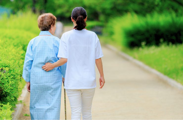 高齢者女性と歩く介護士
