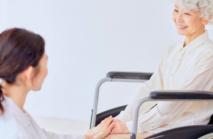 特別養護老人ホームの仕事内容と給料!特養と老健の違いや1日の流れ 2 車椅子の女性の手を握る介護士