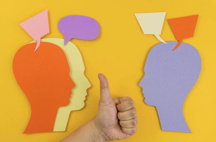 コミュニケーションをイメージした切り絵と中央に親指を立てた手