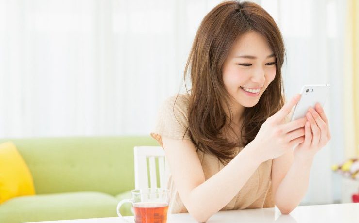 スマホを見て喜ぶ女性