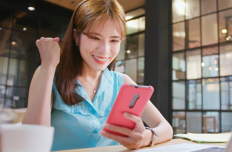 スマホを見て喜ぶ女性