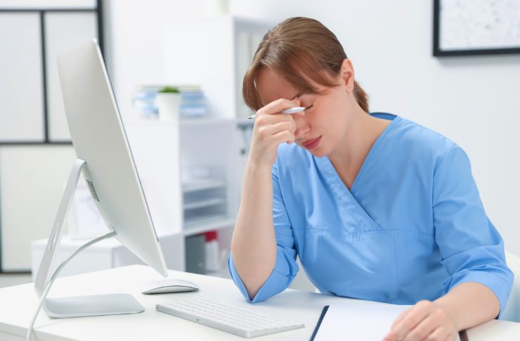 デスクで疲れている様子の介護職