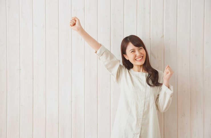 右手を上げて喜んでいる女性